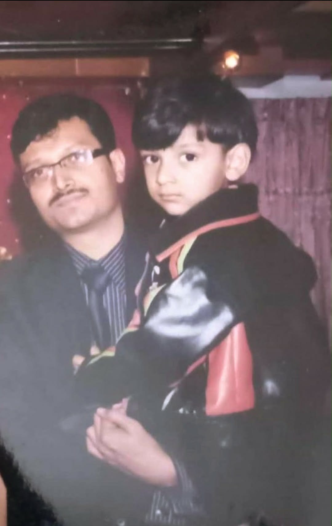 A nostalgic, gently faded photo of my dad holding me in his arms